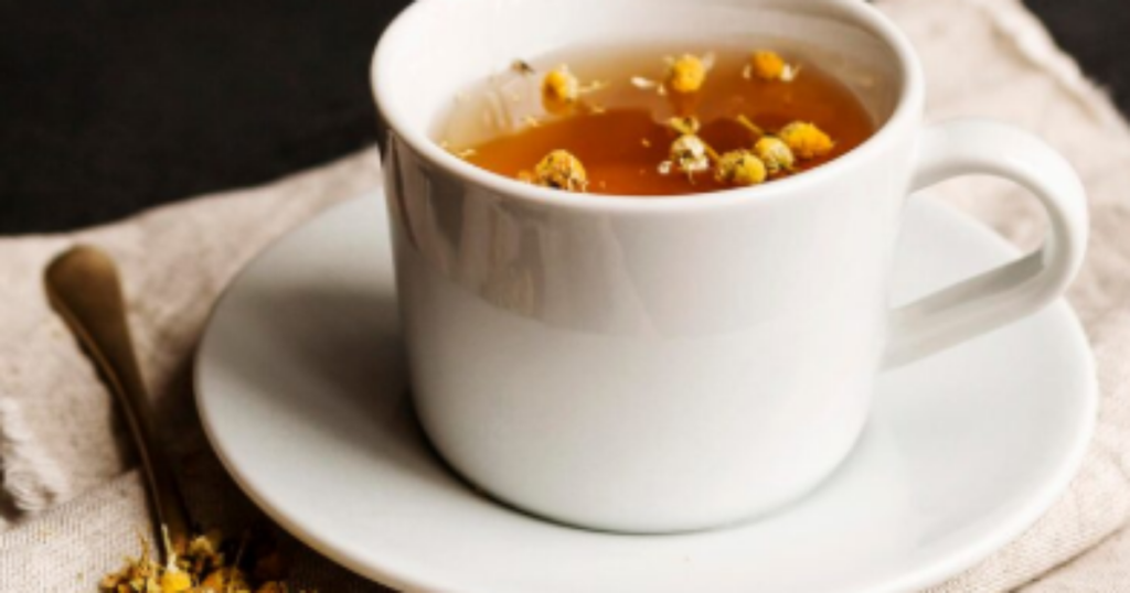 Xícara de chá de mulungu com folhas ao fundo